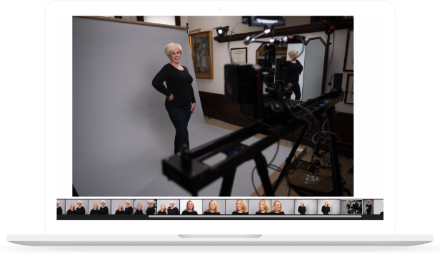 A woman standing in a well lit room, in front of professional camera equipment